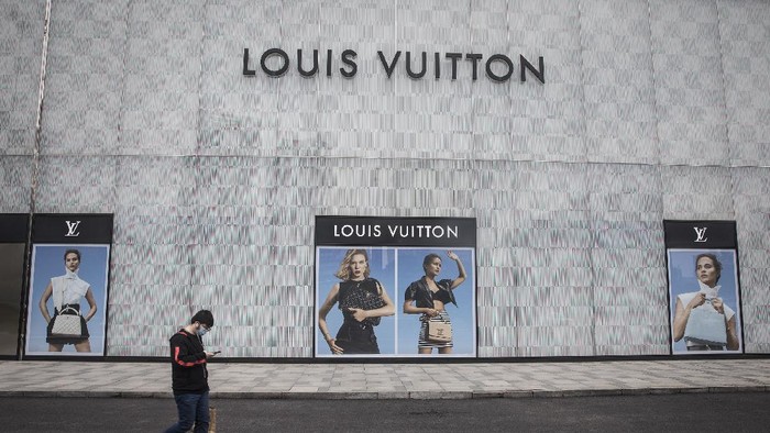 WUHAN, CHINA - MARCH 30: (CHINA OUT) A man wearing a face mask passes a Louis Vuitton store outside Wuhan international plaza on March 30, 2020 in Hubei Province, China. Wuhan, the central Chinese city where the coronavirus (COVID-19) first emerged last year, will lift the lockdown on April 8, local media reported. (Photo by Getty Images)