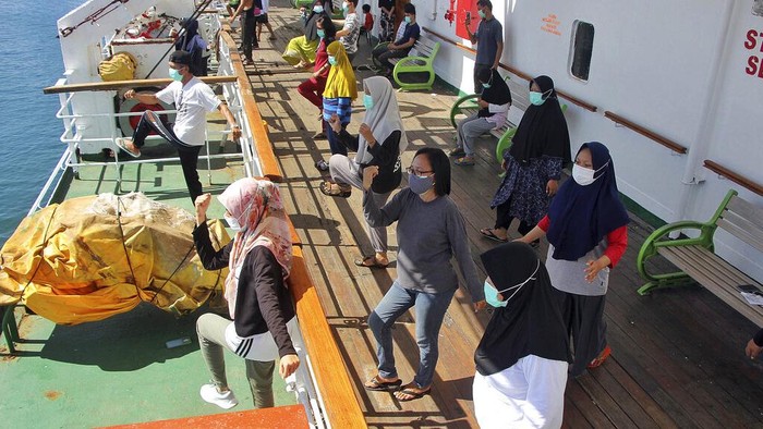 Gerak-gerik Pasien COVID-19 di Kapal Umsini Instructors lead COVID-19 patients through exercises on the deck of the KM Umsini, a passenger ship turned into an isolation center for those with mild symptoms, at Soekarno-Hatta Port in Makassar, South Sulawesi, Indonesia, Sunday, Aug. 8, 2021. Indonesia has the most confirmed daily cases of coronavirus in Asia as infections and deaths have surged over the past month and India's massive outbreak has waned. (AP Photo/Masyudi Syachban Firmansyah)