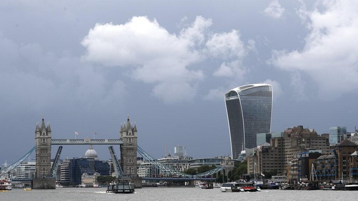 A view of Tower Bridge, center, on the River Thames at sunset in London stuck fully open on Monday Aug. 9, 2021. London's Tower Bridge was stuck with its roadway arms raised Monday afternoon, snarling traffic on both sides of the River Thames.(AP Photo/Tony Hicks)