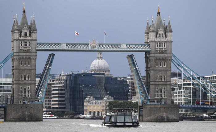 A view of Tower Bridge, center, on the River Thames at sunset in London stuck fully open on Monday Aug. 9, 2021. Londons Tower Bridge was stuck with its roadway arms raised Monday afternoon, snarling traffic on both sides of the River Thames.(AP Photo/Tony Hicks)