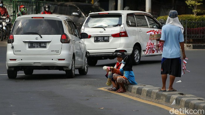 Dua anak menawarkan jasa membersihkan kaca mobil di perempatan lampu merah di Kota Bekasi. Di masa pertumbuhan, mereka terpaksa bekerja karena suatu keadaan.