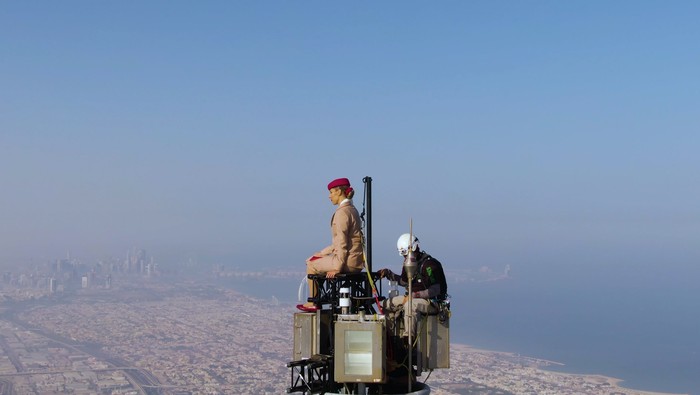Pramugari Emirates Seorang pramugari dengan tersenyum menunjukkan lembaran kertas dengan tulisan ajakan untuk terbang dengan maskapai Emirates. Tak main-main, dia berdiri di puncak menara Burj Khalifa.