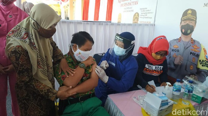 Tangan Kelvin Adi Widaryanto (17) tampak gemetar. Matanya terus mengamati lengan kirinya yang hendak disuntik vaksin. Meski tak menangis, namun tangan dia kepalkan pertanda takut jarum suntik.