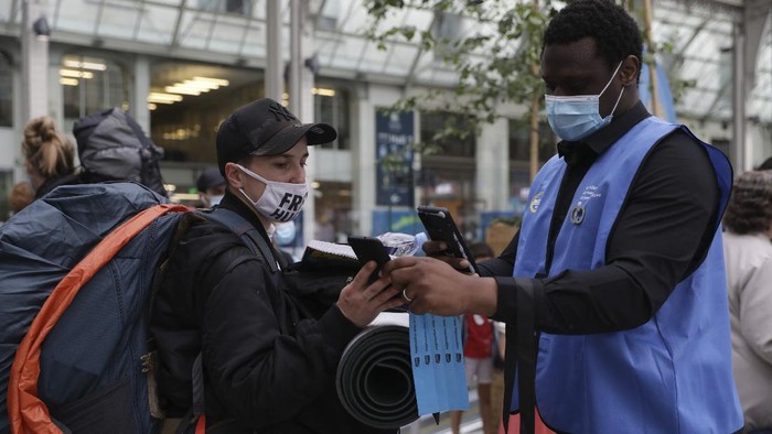 Warga Prancis Wajib Bawa Kartu Sehat Jika Bepergian A waiter checks clients' health passes at a restaurant in Paris, Monday Aug.9, 2021. People in France are now required to show a QR code proving they have a special virus pass to enjoy restaurants and cafes or travel across the country. The measure is part of a government plan to encourage more people to get the vaccine and to slow down a surge in infections, as the highly contagious delta variant now accounts for most cases in France.(AP Photo/Adrienne Surprenant)