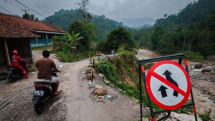 HIMBAUAN WASPADA LONGSOR AKIBAT CURAH HUJAN TINGGI Pengendara roda dua melintas di jalan yang longsor di Desa Banjarsari, Lebak, Banten, Selasa (10/8/2021). Badan Penanggulangan Bencana Daerah (BPBD) Kabupaten Lebak mengimbau masyarakat yang tinggal di perbukitan dan pegunungan mewaspadai bencana longsor yang diakibatkan curah hujan tinggi. ANTARA FOTO/Muhammad Bagus Khoirunas/rwa.