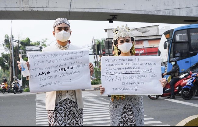 Adalah YouTuber Muhamad Lufti Agizal dan calon istri Nadya Indry membuat heboh warganet di Instagram. Keduanya melakukan aksi protes di pinggir jalan terkait dengan kebijakan PPKM sambil melakukan sesi foto prewedding. Foto: Dok. Instagram @lutfiagizal.