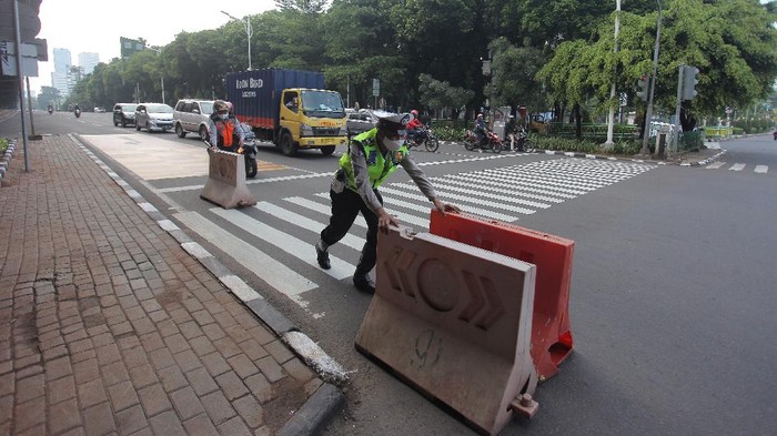 Personel kepolisian membuka pembatas jalan penyekatan di kawasan Jalan Fatmawati,  Jakarta, Rabu (11/8/2021). Direktorat Lalu Lintas Polda Metro Jaya menghapus penyekatan di 100 titik Jakarta, Depok, Tangerang dan Bekasi (Jadetabek) menyusul pemberlakuan uji coba kebijakan ganjil-genap di Ibu Kota pada 10-16 Agustus 2021. ANTARA FOTO/ Reno Esnir/wsj.
