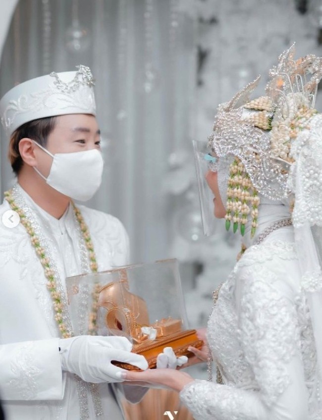 Kini Hwang Woo Joong atau Ujung Oppa telah resmi menikahi Kania. Akad nikah digelar dengan konsep adat Sunda. Pasangan pengantin itu memakai busana pengantin serba putih. Foto: Dok. victoriousprojects, Instagram @kania_permatasari