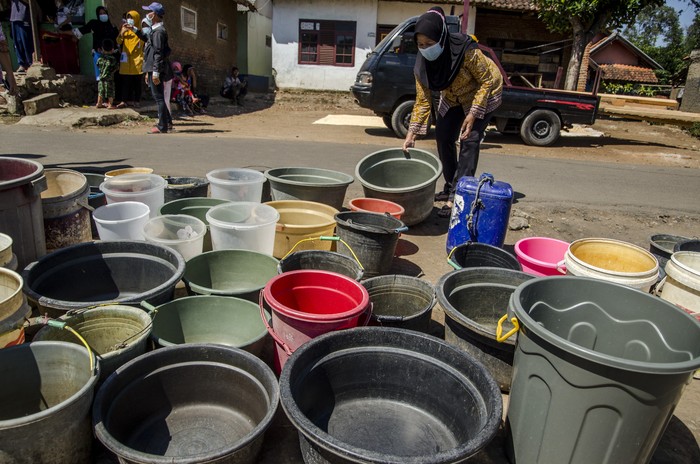 WARGA ANTRE AIR BERSIH DI GARUT Warga meletakkan ember di antrean untuk diisi air bersih bantuan dari Pemprov Jawa Barat di Desa Kertajaya, Garut, Jawa Barat, Rabu (11/8/2021). Sedikitnya enam ribu jiwa dari 13 Rukun Warga di Desa Kertajaya tersebut mengalami kekurangan pasokan air bersih akibat kekeringan dan berkurangnya debit air pada sumber air warga saat musim kemarau yang terjadi tiap tahun. ANTARA FOTO/Novrian Arbi/wsj.