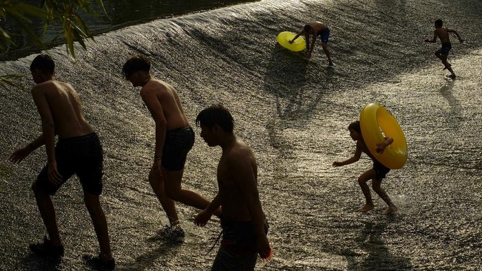 People cool off in water of the Arga River during a hot summer day in Pamplona, northern Spain, Wednesday, Aug. 11, 2021. (AP Photo/Alvaro Barrientos)