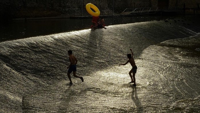 People cool off in water of the Arga River during a hot summer day in Pamplona, northern Spain, Wednesday, Aug. 11, 2021. (AP Photo/Alvaro Barrientos)