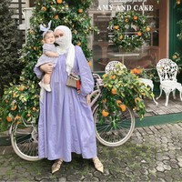 Saat keluar rumah, Dian Pelangi mengenakan dress lilac dan hijab pashmina putih. Ia berpose sambil menggendong Rumi yang memakai dres dan headband. Foto: Dok. Instagram @dianpelangi.