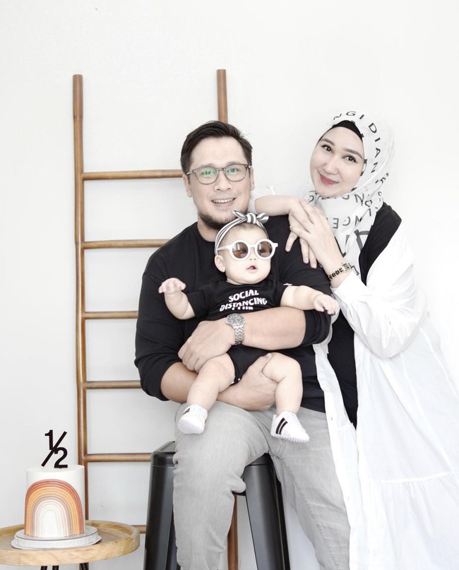 Sandy Nasution dan Dian Pelangi melakukan perayaan ulang tahunn Rumi yang menginjak usia enam bulan #dirumahaja. Ketiganya kompak mengenakan busana monokrom. Foto: Dok. Instagram @dianpelangi.