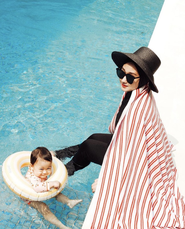 Foto OOTD Dian Pelangi kali ini, Rumi sedang asyik berada di kolam renang. Dian tampil cetar dengan memakai topi dan kacamata hitam. Foto: Dok. Instagram @dianpelangi.