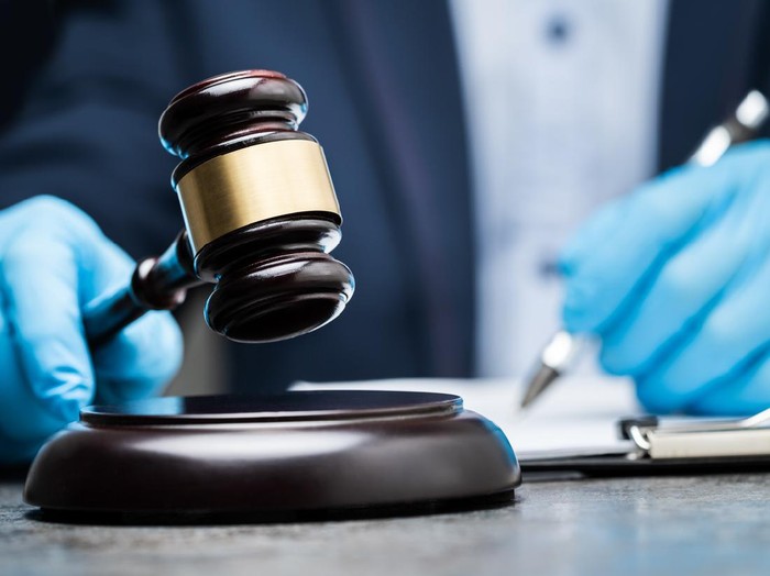Judge In Gloves To Protect From Coronavirus Writing On Paper