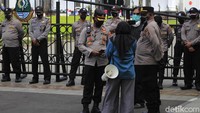 Salah seorang peserta aksi mendekati polisi, sambil menanyakan apa solusi yang ditawarkan aparat agar terbebas dari pandemi ini.
