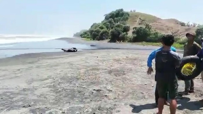 Petugas dibantu warga melakukan pencarian santri yang hilang terseret ombak