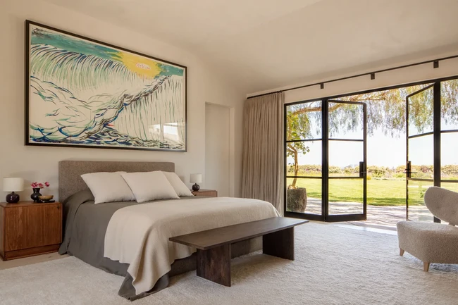 Sebuah lukisan besar karya Raymond Pettibon menghiasi area dinding di atas ranjang mereka. Mungkin ini tidak cocok untuk lokasi yang rawan gempa. Tapi kami bersedia mati demi karya seni ini, canda Adam.  (Foto: Architectural Digest/William Abranowicz)