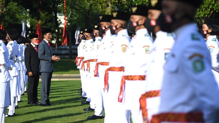 Anggota Pasukan Pengibar Bendera Pusaka (Paskibraka) asal DKI Jakarta Febitri Nur Tsabitah memegang bendera Merah Putih saat mengikuti Upacara Pengukuhan Paskibraka yang dipimpin Presiden Joko Widodo di halaman Istana Merdeka, Jakarta, Kamis (12/8/2021). Presiden Joko Widodo mengukuhkan 68 orang anggota Paskibraka yang akan bertugas pada upacara peringatan Hari Kemerdekaan ke-76 Republik Indonesia di Istana Merdeka pada tanggal 17 Agustus mendatang. ANTARA FOTO/Biro Pers Media Setpres/Lukas/Handout/wsj.