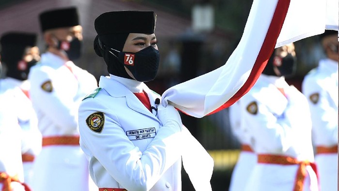 Anggota Pasukan Pengibar Bendera Pusaka (Paskibraka) asal DKI Jakarta Febitri Nur Tsabitah memegang bendera Merah Putih saat mengikuti Upacara Pengukuhan Paskibraka yang dipimpin Presiden Joko Widodo di halaman Istana Merdeka, Jakarta, Kamis (12/8/2021). Presiden Joko Widodo mengukuhkan 68 orang anggota Paskibraka yang akan bertugas pada upacara peringatan Hari Kemerdekaan ke-76 Republik Indonesia di Istana Merdeka pada tanggal 17 Agustus mendatang. ANTARA FOTO/Biro Pers Media Setpres/Lukas/Handout/wsj.