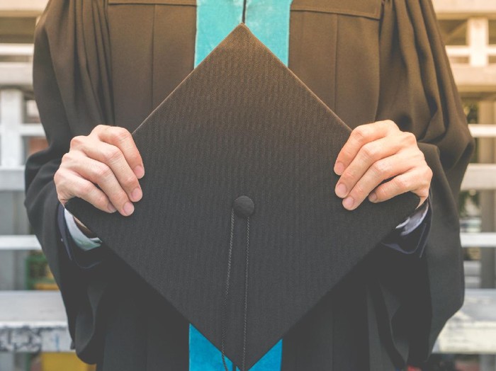 Proud mother hugging her graduating son and looking very happy â education concepts