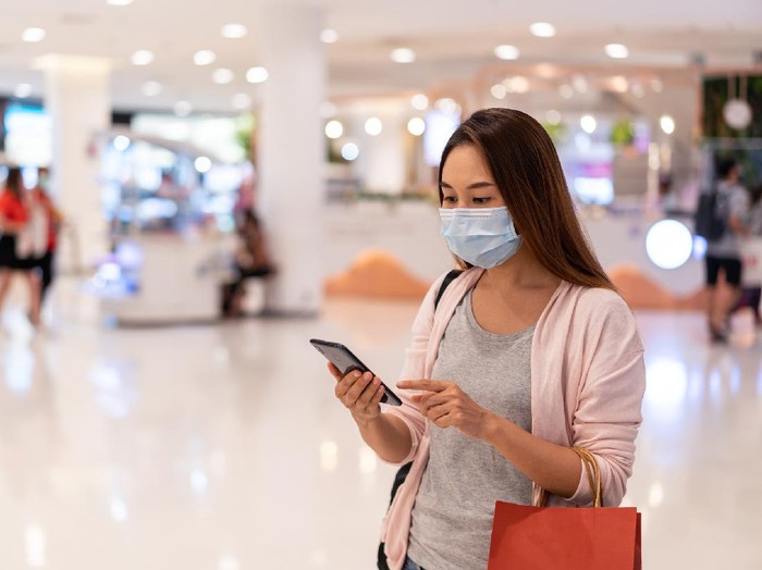 1255924649 Young asian woman wearing surgical mask shopping in clothes store at the mall, New normal and lifestyle concept