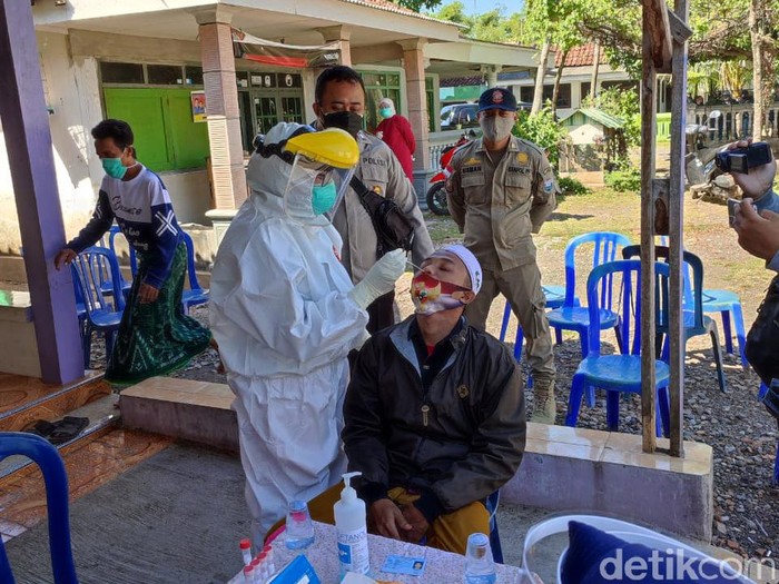 Puluhan warga Desa Tigasan Wetan, Kecamatan Leces, Kabupaten Probolinggo merebut jenazah COVID-19 saat pemakaman dengan prokes. Hari ini mereka menjalani swab PCR.