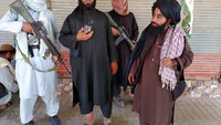 Potret pejuang Taliban saat berpatroli dengan membawa senapan dan bendera di Ibu Kota Provinsi Farah, Farah (10/8).  (AP Photo/Mohammad Asif Khan)