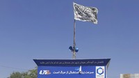 Bendera Taliban dikibarkan di alun-alun Ibu Kota Kunduz, Afghanistan (8/8). Selain Kunduz, sejumlah kota lain telah jatuh ke tangan Taliban.  (AP Photo/Abdullah Sahil)