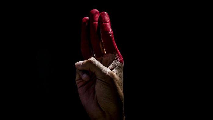 Foto: Ancaman Perang Saudara di Myanmar TOKYO, JAPAN - MAY 02: A Myanmarese resident in Japan holds up the three finger salute during a protest on May 02, 2021 in Tokyo, Japan. Myanmar has now entered its fourth month under a military coup that ousted the elected government led by Aung San Suu Kyi. The overthrow triggered a large uprising by democracy protesters which was met with brutal force by the authorities. (Photo by Yuichi Yamazaki/Getty Images)