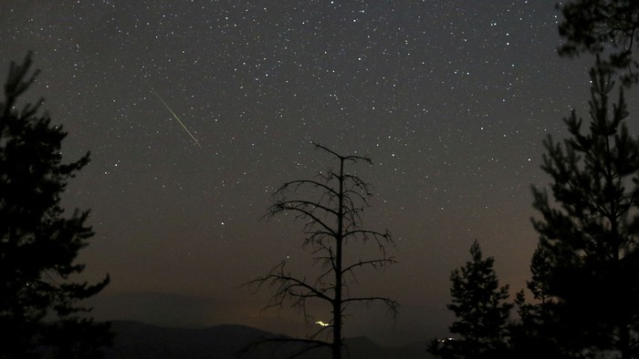 A meteor dashes above Tvrtkovac mountain during the Perseid meteor shower seen from Zenica, Bosnia and Herzegovina, August 8, 2021.  REUTERS/Dado Ruvic     TPX IMAGES OF THE DAY