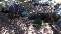 Penampakan tiga orang anak yang tertidur di sebuah taman usai meninggalkan rumah mereka imbas pertempuran antara Taliban dan personel keamanan Afghanistan beberapa waktu lalu. AP Photo/Rahmat Gul.