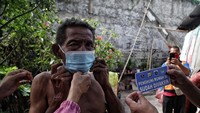 Tampak seorang warga dipakaikan masker.