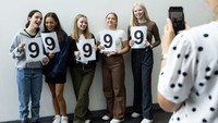 Para siswa berpose untuk guru mereka, dengan menunjukkan nilai setelah membuka hasil GCSE mereka di City of London Academy, pada 12 Agustus 2021 di London, Inggris.