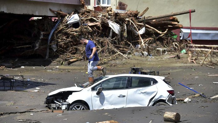A man checks his car buried in the mud after floods and mudslides killed about three dozens of people, in Bozkurt town of Kastamonu province, Turkey, Friday, Aug. 13, 2021. The death toll from devastating floods and mudslides in northern Turkey rose to at least 31 on Friday, officials said, as emergency services searched for survivors in collapsed buildings or swamped homes, shops and basements. An opposition politician said more than 300 people may be unaccounted-for.(AP Photo)