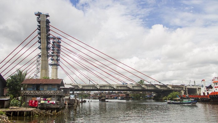 PEMBANGUNAN JEMBATAN SUNGAI ALALAK BANJARMASIN Pekerja menyelesaikan proyek pembangunan jembatan Sungai Alalak di Banjarmasin, Kalimantan Selatan, Sabtu (14/8/2021). Progres pembangunan jembatan Sungai Alalak yang menghubungkan Kota Banjarmasin dengan Kabupaten Barito Kuala yang menjadi ikonik dan sebuah wisata baru oleh pemerintah Kota Banjarmasin tersebut sudah mencapai 93,2 persen dan ditargetkan rampung pada 15 September 2021. ANTARA FOTO/Bayu Pratama S/rwa.