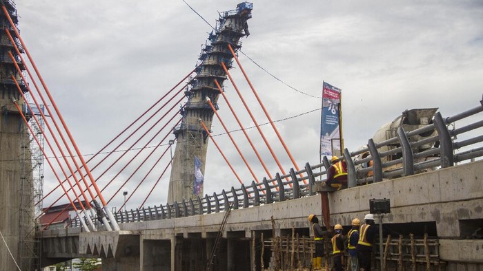 Pekerja menyelesaikan proyek pembangunan jembatan Sungai Alalak di Banjarmasin, Kalimantan Selatan, Sabtu (14/8/2021). Progres pembangunan jembatan Sungai Alalak yang menghubungkan Kota Banjarmasin dengan Kabupaten Barito Kuala yang menjadi ikonik dan sebuah wisata baru oleh pemerintah Kota Banjarmasin tersebut sudah mencapai 93,2 persen dan ditargetkan rampung pada 15 September 2021. ANTARA FOTO/Bayu Pratama S/rwa.