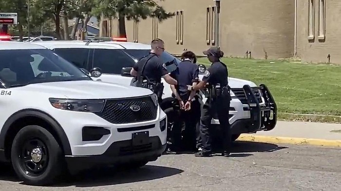 In this image from taken from video courtesy of Ryan Laughlin/KOB 4 TV Albuquerque Police Department officers search a student after a shooting at Washington Middle School which left at least one student dead and another in custody, police said Friday, Aug. 13, 2021. Only a few days into the new school year and New Mexicos largest district was left reeling from the shooting. Authorities said Fridays shooting was an isolated incident between two Washington Middle School students who were believed to be about 13 years old. (Ryan Laughlin/KOB 4 TV via AP)