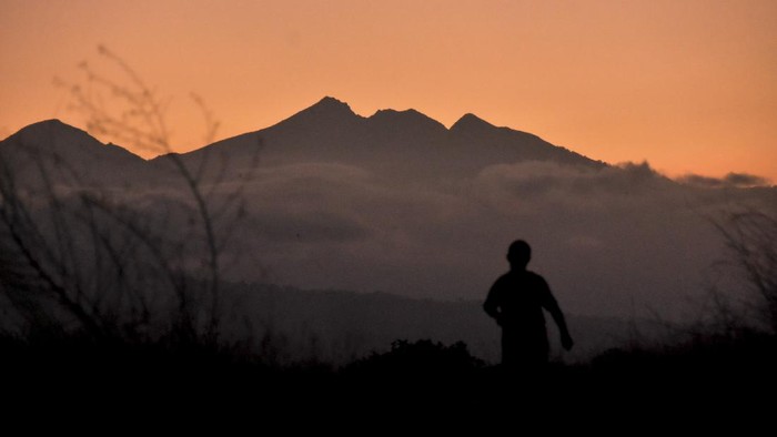 Siluet puncak Gunung Rinjani terlihat jelas saat matahari terbit dari Kota Mataram, NTB, Sabtu (14/8/2021). Gunung Rinjani yang terletak di bagian utara Pulau Lombok merupakan gunung berapi tertinggi kedua di Indonesia dengan ketinggian 3,726 mdpl dan menjadi salah satu tempat wisata pegunungan favorit di NTB. ANTARA FOTO/Ahmad Subaidi/rwa.