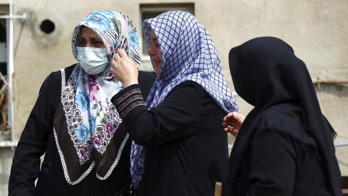 Women react as they look at the destroyed building where they lived, in Bozkurt town of Kastamonu province, Turkey, Saturday, Aug. 14, 2021. The death toll from severe floods and mudslides in coastal Turkey has climbed to at least 44, the country's emergency and disaster agency said Saturday. Torrential rains that pounded the Black Sea provinces of Bartin, Kastamonu and Sinop on Wednesday caused flooding that demolished homes, severed at least five bridges, swept away cars and rendered numerous roads unpassable. (AP Photo)
