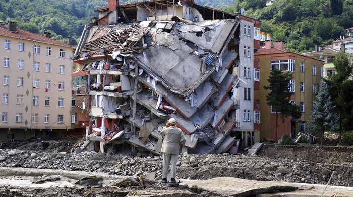 Turkey Floods Women react as they look at the destroyed building where they lived, in Bozkurt town of Kastamonu province, Turkey, Saturday, Aug. 14, 2021. The death toll from severe floods and mudslides in coastal Turkey has climbed to at least 44, the country's emergency and disaster agency said Saturday. Torrential rains that pounded the Black Sea provinces of Bartin, Kastamonu and Sinop on Wednesday caused flooding that demolished homes, severed at least five bridges, swept away cars and rendered numerous roads unpassable. (AP Photo)