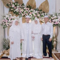 Henny Rahman dan Alvin Faiz kompak mengenakan busana serba putih yang simpel di hari pernikahan mereka. Alvin memakai jas putih panjang. Sedangkan Henny tampak menggunakan dress putih. Foto: dok. Instagram @umi_yuni_syahla_aceh