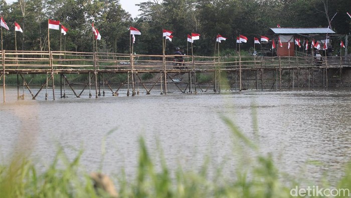 Jembatan bambu di Kulon Progo tampak dihiasi puluhan bendera Merah Putih. Hal itu dilakukan dalam rangka menyambut HUT RI ke-76 pada 17 Agustus 2021 mendatang.