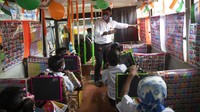 Seorang aktivis sosial di India, Ashok Kurmi tengah mengajar sejumlah anak di bus yang dirombak menjadi ruang kelas keliling di Mumbai, Minggu (15/8/2021).