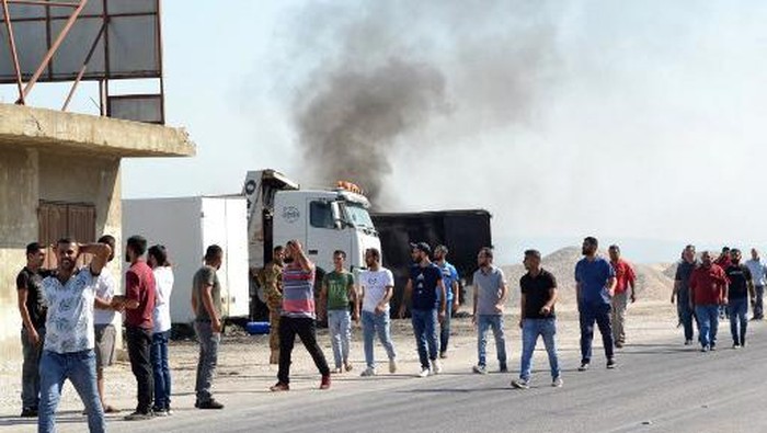 A picture taken on August 15, 2021, shows people gathering at the site of a fuel tank explosion in the village of Tlel in Lebanons northern region of Akkar. - At least 20 people were killed and nearly 80 others injured when a fuel tank exploded in Lebanons northern region of Akkar, the Red Cross and state media said. The official National News Agency said the explosion took place following scuffles between 