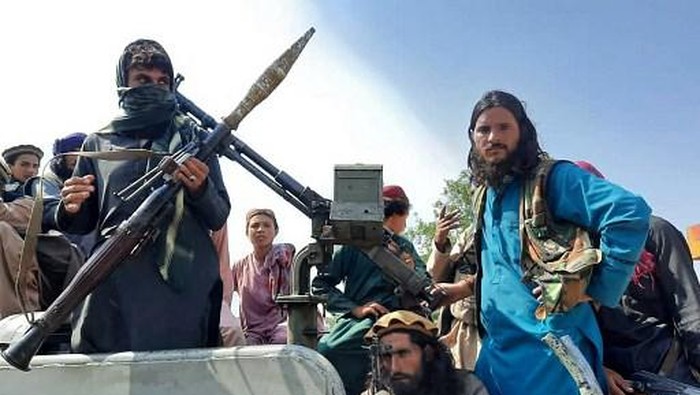 Taliban fighters sit over a vehicle on a street in Laghman province on August 15, 2021. (Photo by - / AFP)