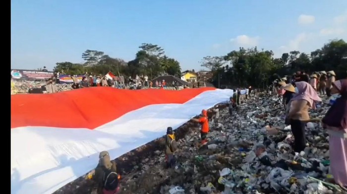 Bendera merah putih dibentangkan di tempat pembuangan akhir sampah di Tasikmalaya.