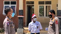 Kapolres Belu AKBP Khairul Saleh (kanan) berbincang-bincang dengan Joni bocah pemanjat tiang bendera (ANTARA/Ho-Humas Polres Belu)