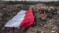 Foto udara pembentangan bendera merah putih oleh sejumlah pegiat lingkungan yang tergabung dalam komunitas Republik Aer di Tempat Pembuangan Akhir Sampah (TPAS) Cianggir, Kota Tasikmalaya, Jawa Barat, Minggu (15/8/2021). Pembentangan bendera merah putih raksasa di TPAS tersebut dilakukan dalam rangkaian acara menyambut peringatan HUT Kemerdekaan ke-76 RI, sekaligus mengampanyekan kepedulian terhadap lingkungan dan menjaga ekosistem di masa pandemi COVID-19 serta memupuk rasa nasionalisme. ANTARA FOTO/Adeng Bustomi
