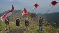 Sejumlah aktivis Komunitas Sahabat Bumi mengibarkan Bendera Merah Putih di Gunung Peda, di Kampung Pabean, Kecamatan Purwakarta, Cilegon, Banten, Minggu (15/8/2021). Acara tersebut digelar untuk menyambut HUT ke-76 Kemerdekaan Republik Indonesia dan memupuk rasa nasionalisme. ANTARA FOTO/Asep Fathulrahman  